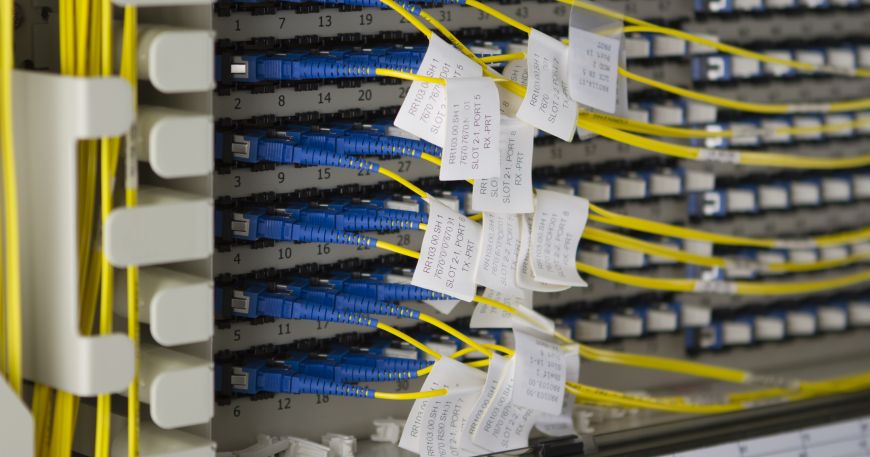 Electrical labels or electronic labels wrapped around a series of cables; each label is printed with identifying information about the relevant cable and port.