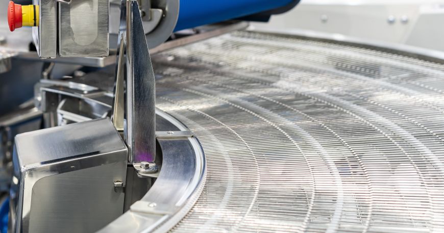 A stainless steel wire mesh belt in a factory; the felt side of paper is the side that did not contact the wire belt during manufacturing.