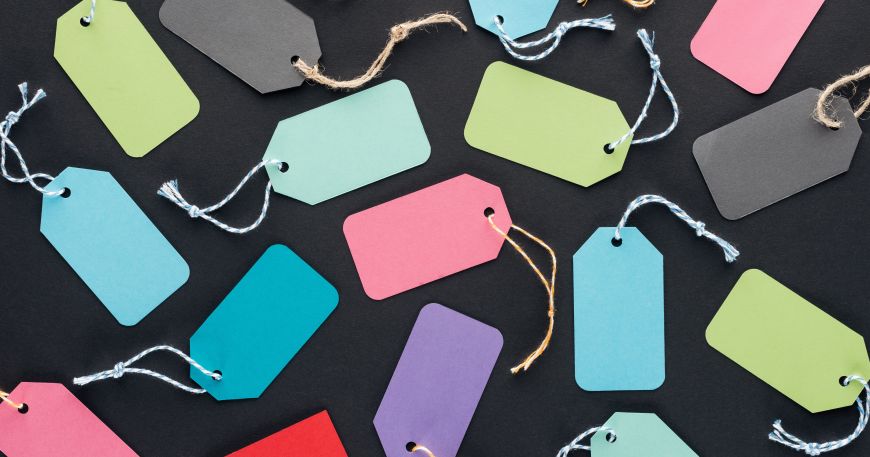 Multicoloured hang tags on a black background. A hang tag is attached to an item using a thread or tie rather than an adhesive.