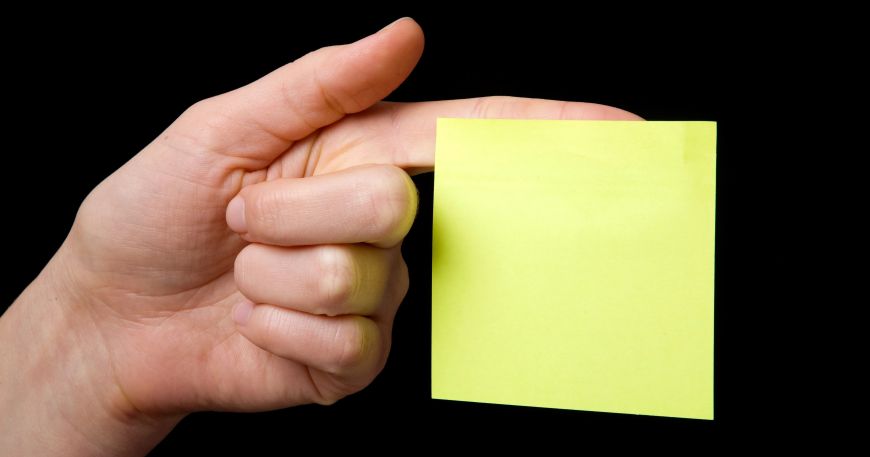 A post it note stuck to a person's forefinger; pressure sensitive adhesives used to make self adhesive labels usually have good initial tack, which allows them to instantly stick to the item or surface being labelled.