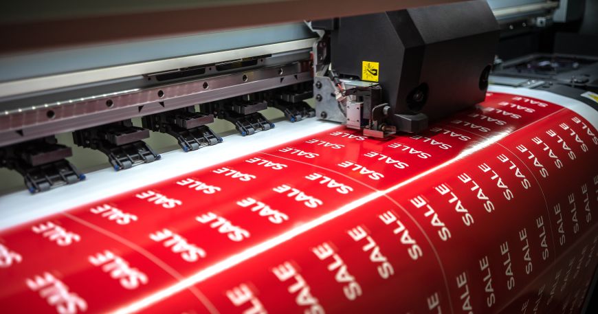 A label design being printed using knock out printing. The printer only prints the red background, which allows the unprinted areas of each white label to form the required text - 