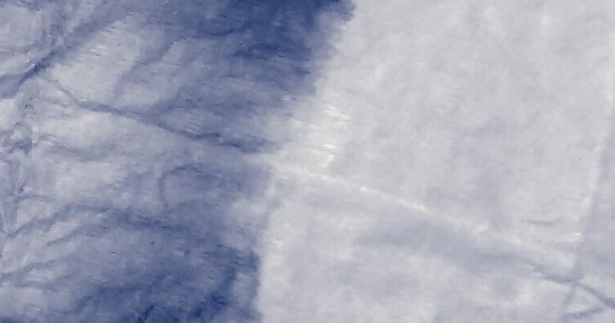 Migration of an indigo dye into a white material.