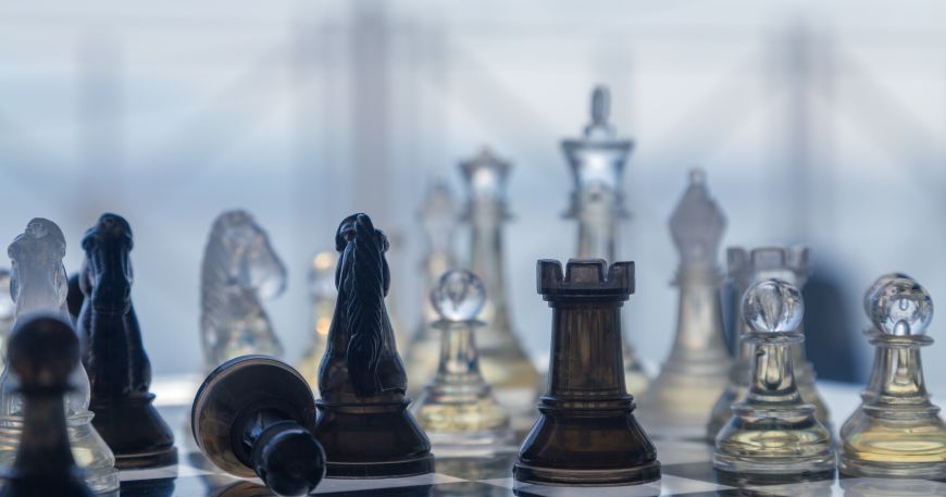 Two sets of chess pieces - one made from a transparent material (right and back) and the other from an opaque material (left). The background can be seen through the transparent pieces but the opaque pieces cannot be seen through at all.