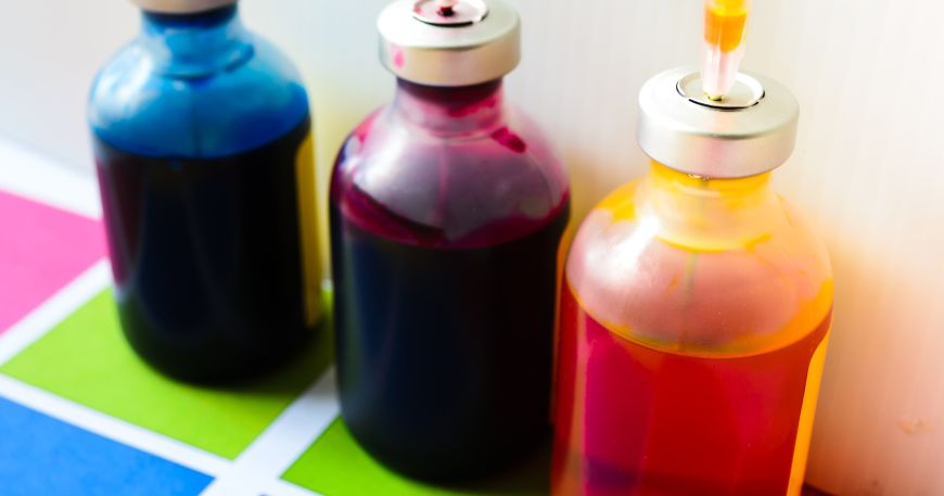 Three bottles of oxidising inks in cyan (blue), magenta (pink), and yellow