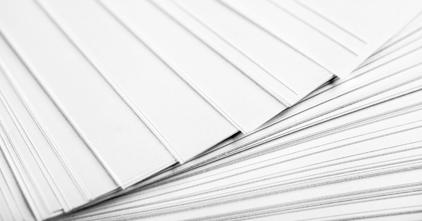A close up of a stack of recycled label sheets, which are all made using recycled paper.