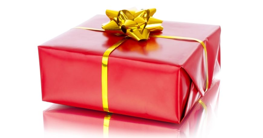 A present wrapped in red wrapping paper with a gold bow. The paper has a semi-gloss finish, while the bow has a full gloss finish.