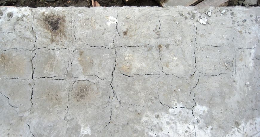 Cracks in a slab of concrete caused by shrinkage. Shrinkage can occur in sheet labels due to environmental factors or the passage of time. 