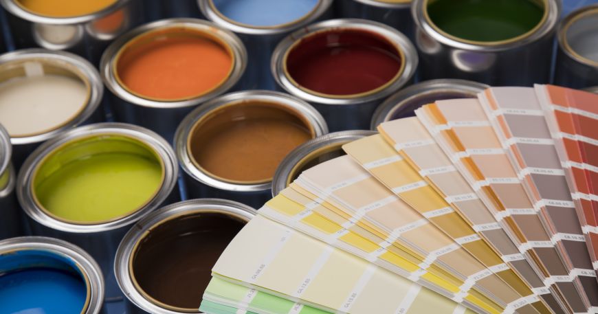 A colour chart (bottom right) next to tins of spot colour paint; spot colour printing uses spot colours of ink that have been pre-mixed to the exact colour required by a particular design.