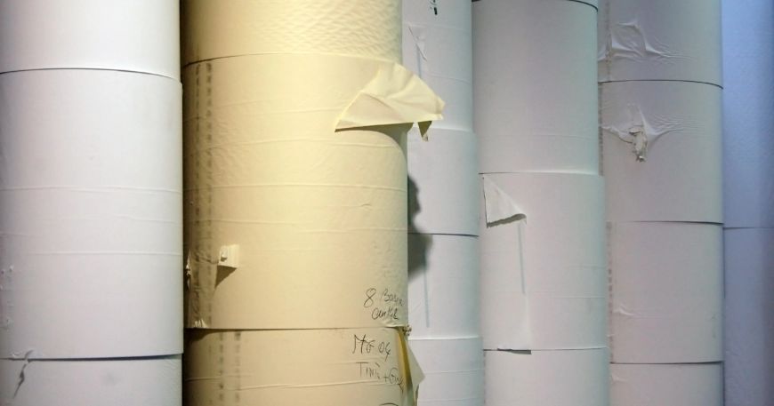 Rolls of paper stock are stacked up in a paper factory.