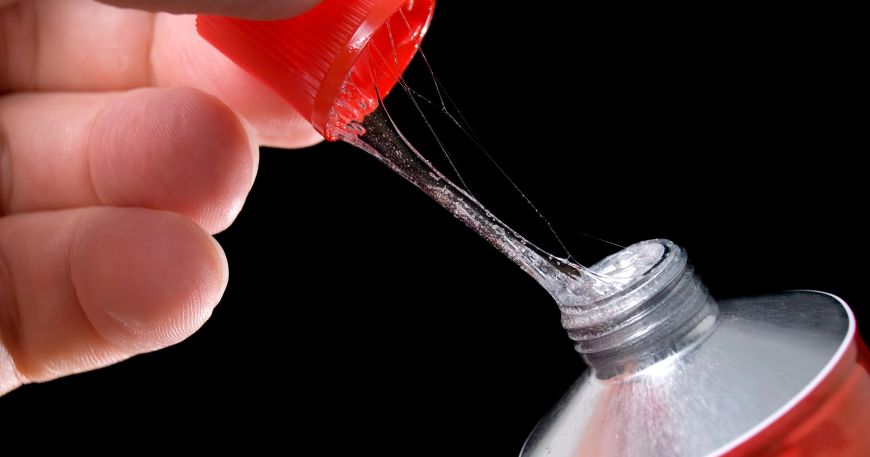 A person opens a tube of glue; the glue in the tube is tacky, or sticky, which means it sticks to the lid as the tube is opened. Tack is what allows materials like glues to stick to a surface immediately on contact.
