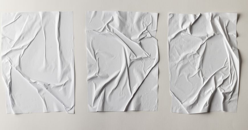Three sheets of paper that have become wrinkled after being exposed to water.