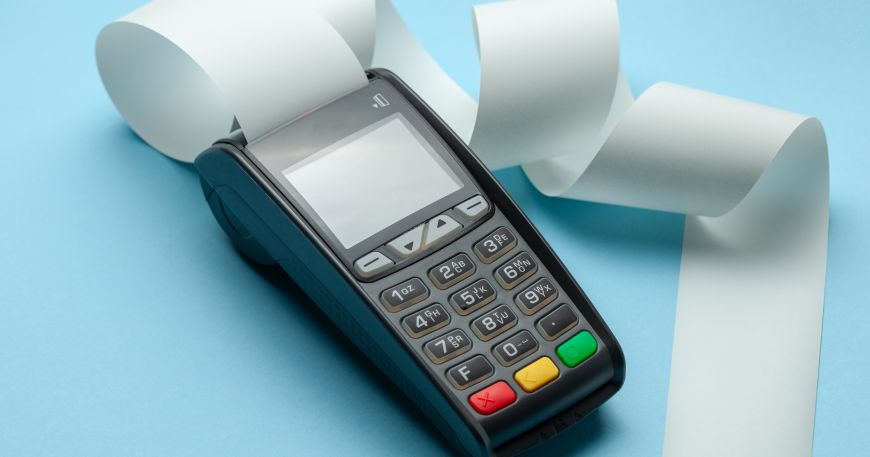 A card machine for taking payments with its roll of thermal paper emerging from the top. Card machines use thermal printing to produce receipts. 