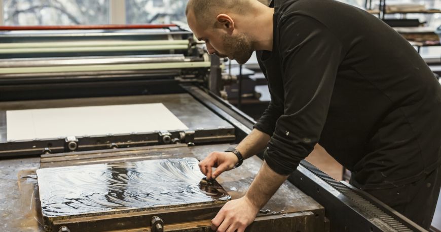 An artist preparing a limestone plate in prepration for producing a lithographic print.