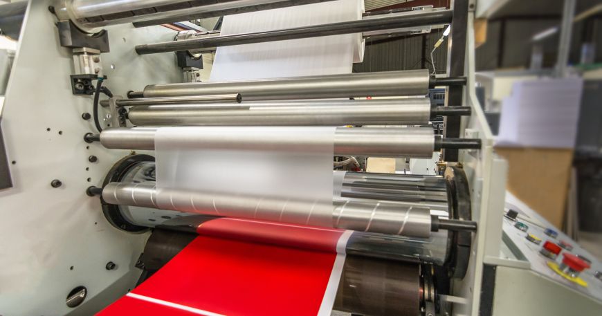 A laminating machine or laminator; a clear film (top) is laminated onto another material (bottom) to form a laminate.