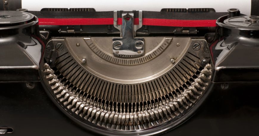 A close up of the printing mechanism in a typewriter, which uses a type of impact printing. Typewriters contain a set of type bars, which strike an ink ribbon against a sheet of paper to produce text.