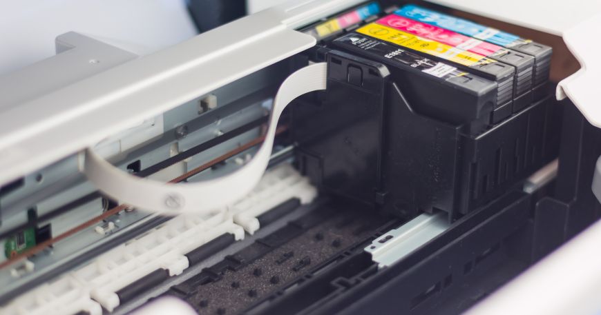 A close up of the inside of an inkjet printer; the printhead and the ink cartridges can be seen on the right hand side.