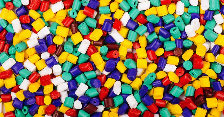 Plastic granules in various colours; all of these plastic granules are made from polymers. 