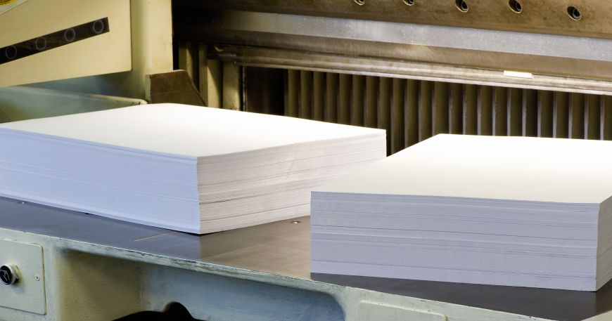 Two reams of paper on a machine for cutting paper. Basis weight is based on the mass of a ream of paper that contains a specific number of sheets cut to a specific size.