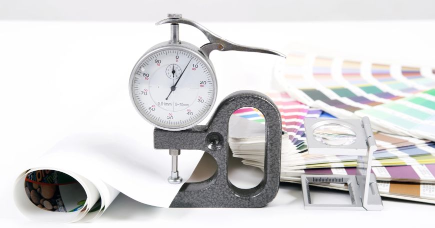 A micrometer being used to measure the caliper, or thickness, of a sheet of paper; the basis weight of the sheet can be divided by the caliper to give the apparent density.