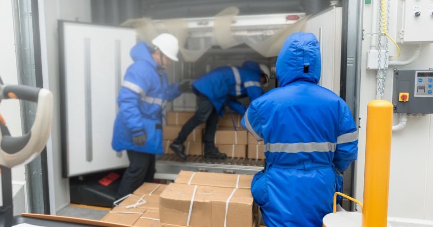 People loading boxes of food into a refridgerated van for delivery. Food is often kept in a variety of environments so packaging may be labelled with all temperature adhesives that can cope with a range of temperatures.