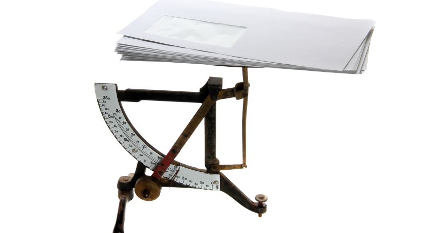 An old fashioned set of scales weighing a small pile of envelopes.