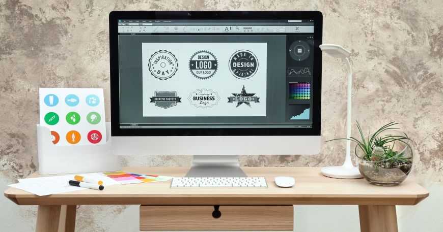 A computer screen dsplays a set of logos being designed using graphics software.