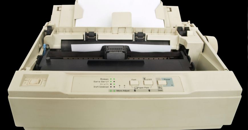 A dot matrix printer loaded with a sheet of white paper.