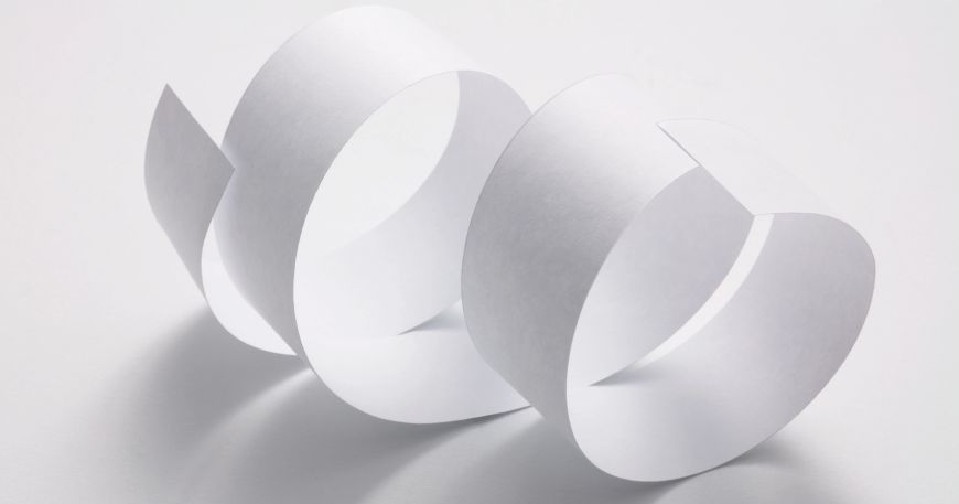 A strip of paper that has curled several times to form a ribbon-like shape.