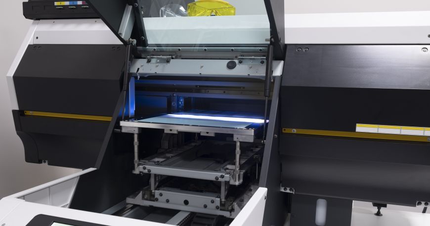 A UV printer being used to print a sheet of paper. This printer uses UV light to cure UV inks. 