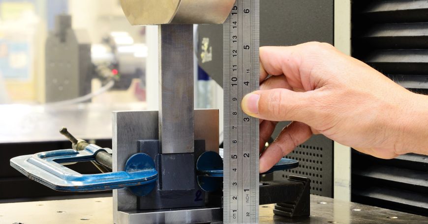 A person conducting a shear stress test on a small sample of material; shear resistance is another name for shear stress, which is an important property for label adhesives.