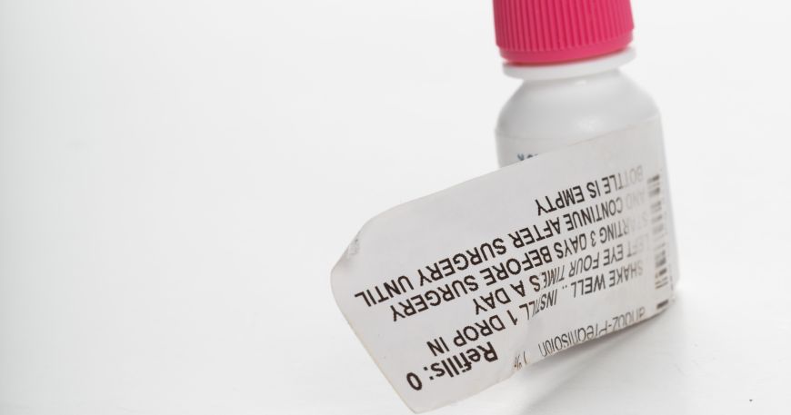 A bottle of eye drops with an expanded content label. The small bottle provides little room for information so the extended content label wraps around the bottle and can be unwrapped to reveal its contents.