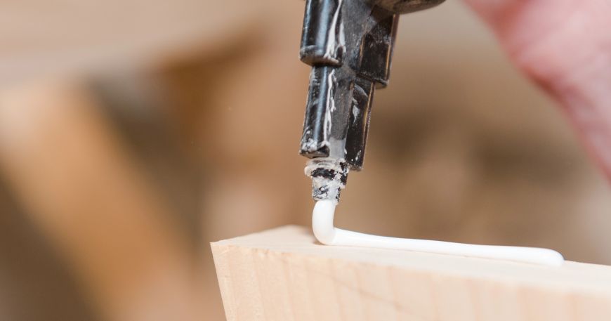 A person applying wood glue; many wood glues are emulsion adhesives, which allows them to be spread in liquid form across wooden surfaces.