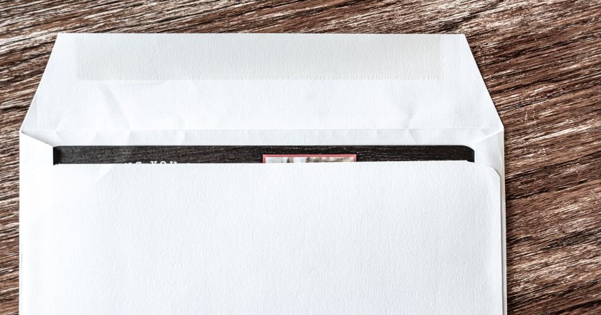 A white envelope that has a strip of gum adhesive along the top edge to allow the envelope to be sealed.