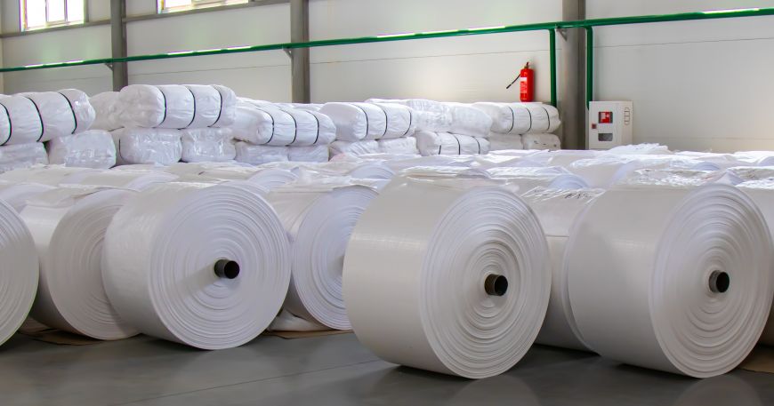 Rolls of white polypropylene film sitting in a warehouse. 