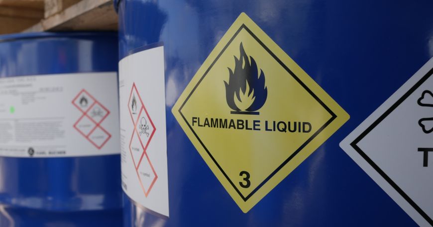 A close up of BS5609 labels stuck onto a blue chemical drum; the labels display clear warnings and information about the contents of the drum.