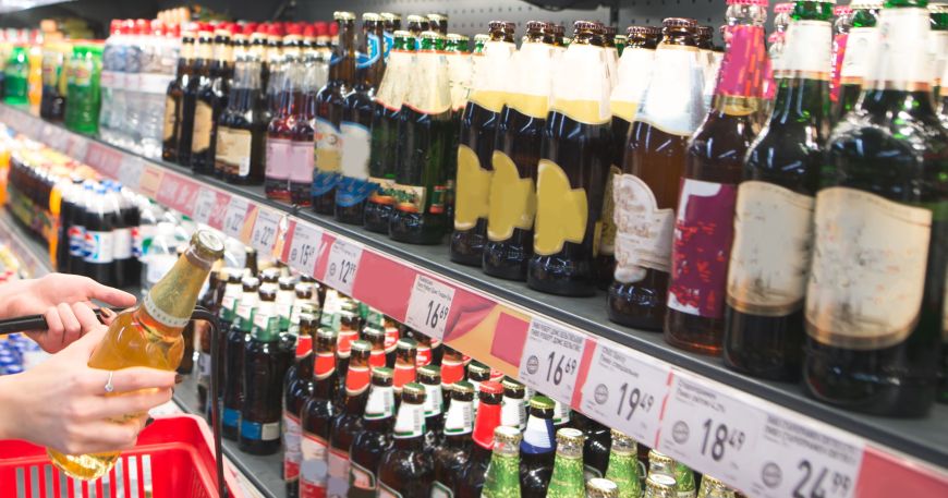 Supermarket shelves containing price labels. Dry peel adhesives hold labels in place during manufacturing and printing but are non-tacky once removed so labels can be slipped into shelf edge strips without sticking.