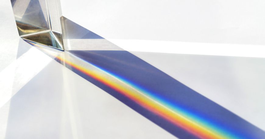 A prism being used to refract light; the brightness of materials is measured by the amount of blue light they reflect under standard conditions.